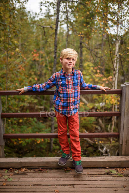 Portrait of a smiling boy standing on a bridge, United States — Stock Photo