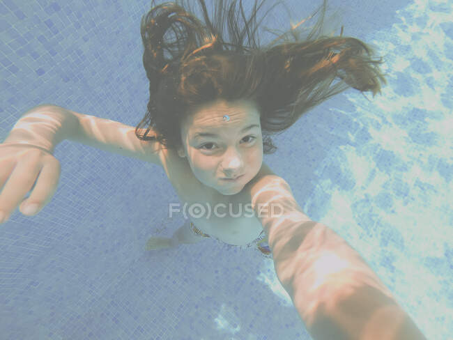 Rapaz a tirar uma selfie debaixo de água numa piscina — Fotografia de Stock