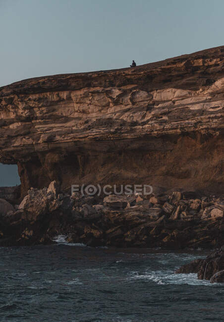 Homme assis sur une falaise méditant, La Pared, Fuerteventura, Îles Canaries, Espagne — Photo de stock
