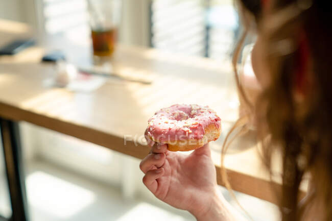 Portrait of a woman holding a donut — Stock Photo