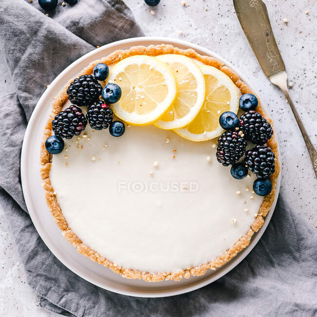 Не пекать лимонный пирог с ломтиками лимона, черникой и ежевикой. — стоковое фото