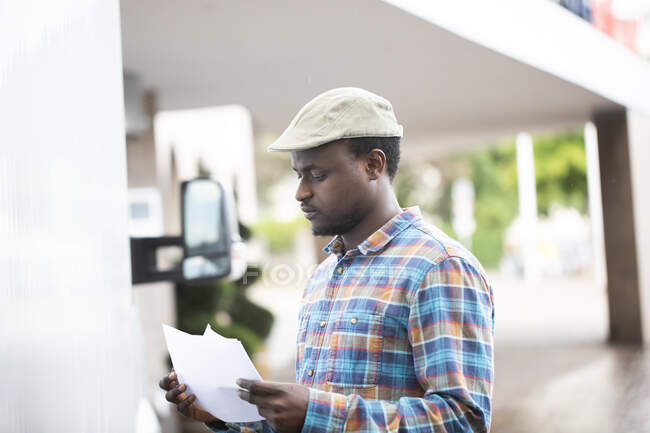 Portrait of a man standing by a truck looking at paperwork — Stock Photo