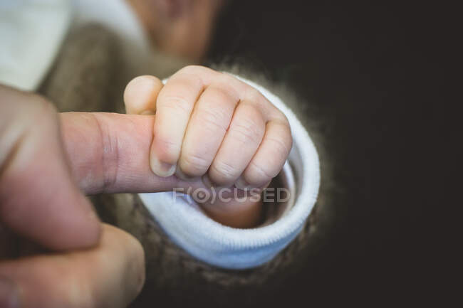 Close-up of a baby holding a parent's finger — Stock Photo