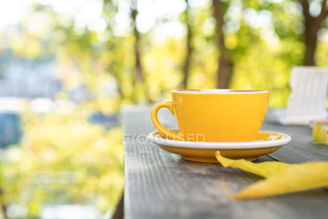 Großaufnahme einer Kaffeetasse auf einem Gartentisch — Stockfoto
