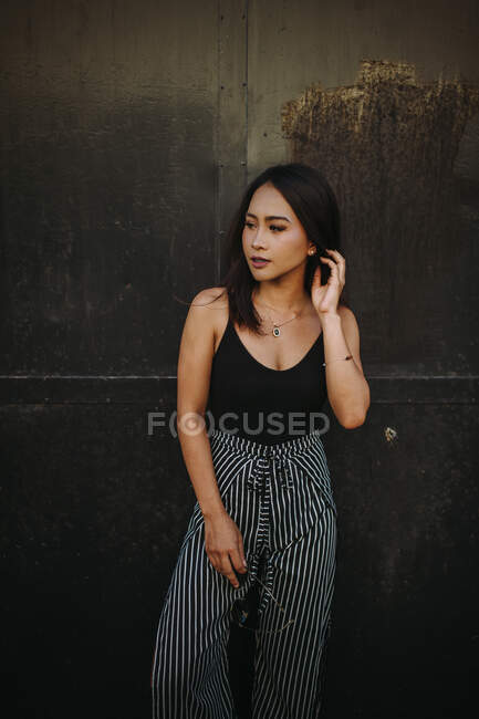 Schöne junge Frau posiert vor Metalltüren — Stockfoto