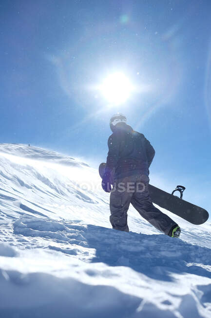 Hombre que lleva una tabla de snowboard, Mammoth Lakes, California, Estados Unidos - foto de stock