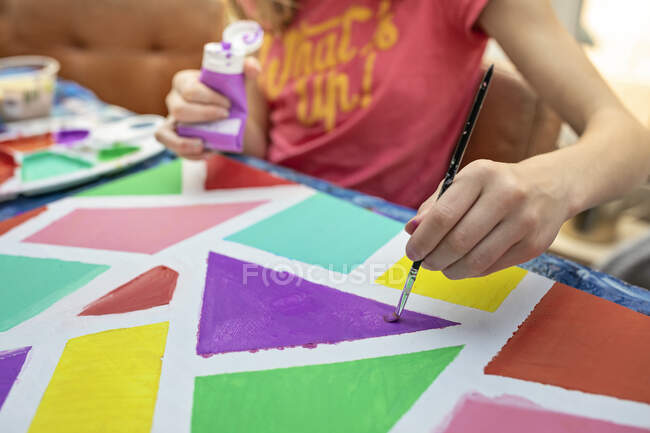 Menina sentada a uma mesa de pintura — Fotografia de Stock