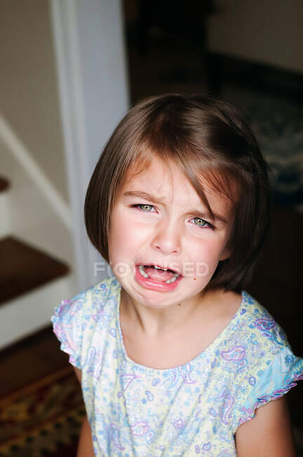 Retrato de niña triste llorando en casa - foto de stock