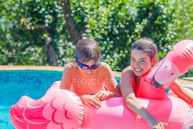 Two people on an inflatable flamingo in a swimming pool, Bulgaria — Foto stock