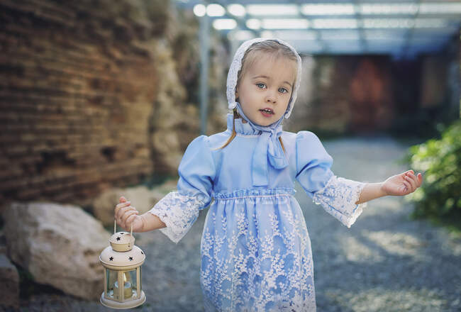 Portrait of a girl wearing a vintage dress carrying a lantern, Bulgaria — Stock Photo