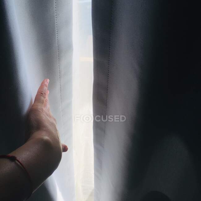 Frauenhand bewegt Vorhang vom Fenster weg — Stockfoto