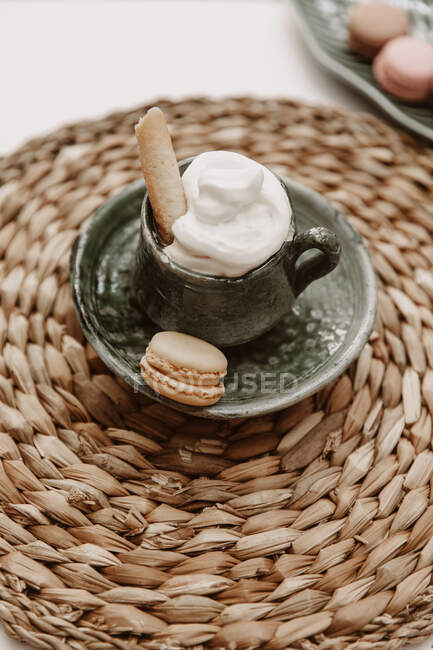 Chocolate caliente con nata batida y macarrón - foto de stock