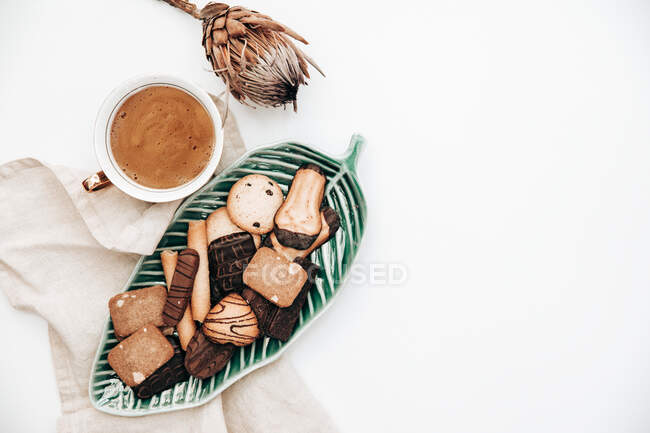 Cup of coffee with cookies and a protea flower — Stock Photo