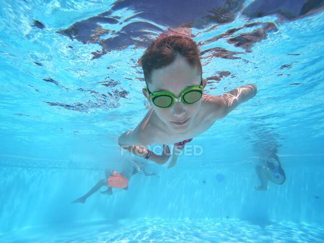 Хлопчик плаває під водою у басейні — стокове фото