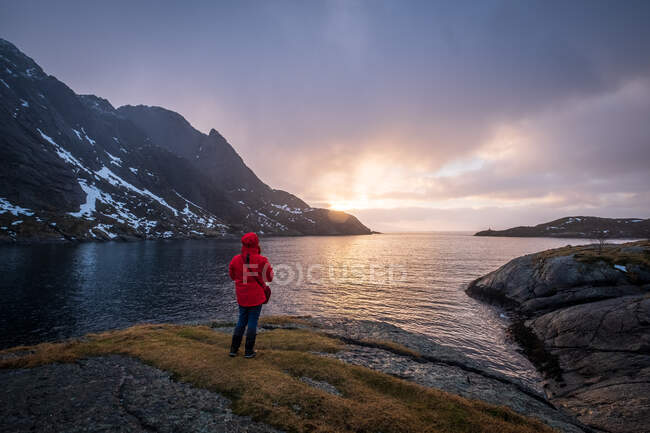 Femme regardant le lever du soleil, Nusfjord, Lofoten, Nordland, Norvège — Photo de stock