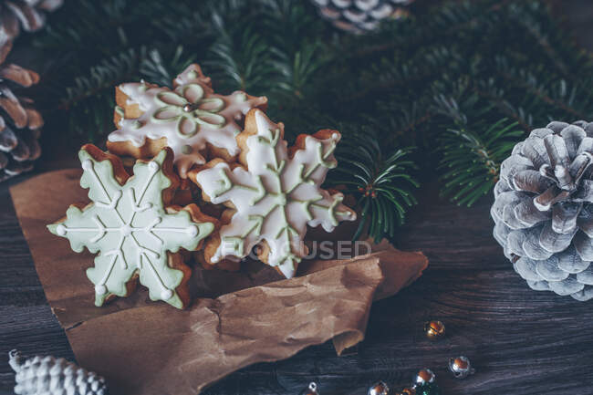 Biscotti al fiocco di neve circondati da decorazioni natalizie — Foto stock