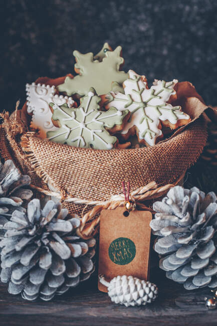 Fiocco di neve e biscotti dell'albero di Natale in una borsa di hessian circondata dalle decorazioni di Natale — Foto stock