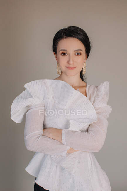 Donna che indossa elegante camicetta arruffata posa alla macchina fotografica — Foto stock