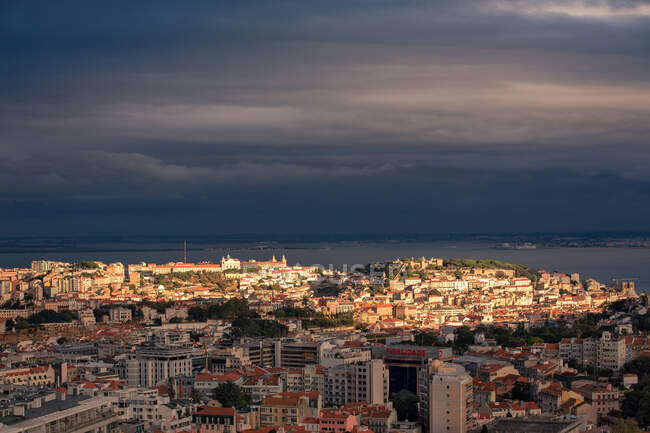 Грозовые тучи над городом на закате, Лиссабон, Португалия — стоковое фото