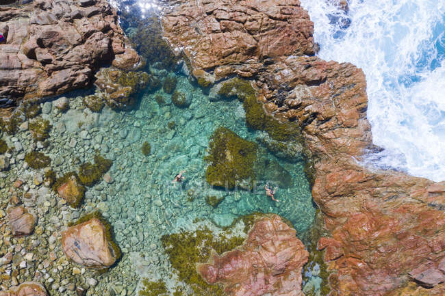 Vista aerea di due bambini che nuotano nella piscina di rocce oceaniche, Australia — Foto stock