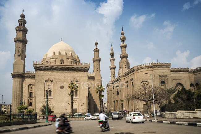 Tráfico pasando por La Mezquita-Madraza del Sultán Hassan, Mokattam Hill, El Cairo, Egipto - foto de stock