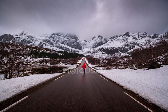 Femme marchant le long de la route du Nusfjord, Flakstad, Nordland, Norvège — Photo de stock