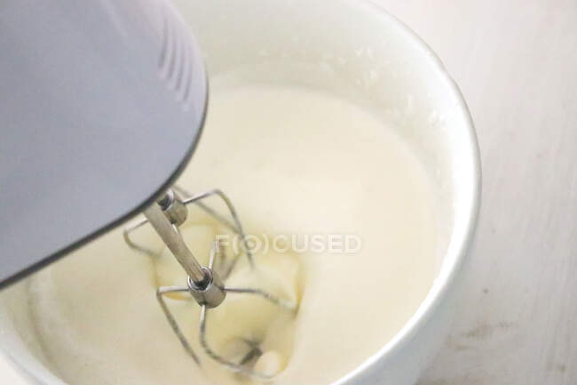 Close-up of an electric whisk whisking double cream — Stock Photo