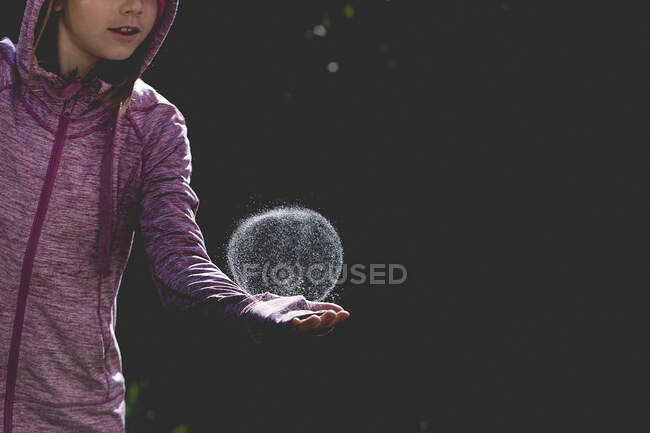 Хлопчик стоїть в саду, балансуючи мильну бульбашку на руці — стокове фото