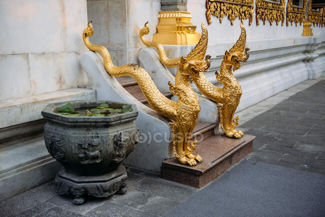 Primer plano de esculturas de dragón junto a una entrada del templo, Bangkok, Tailandia - foto de stock