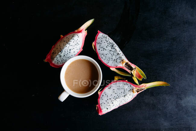 Tasse Tee und Drachenfrucht auf einem Tisch — Stockfoto