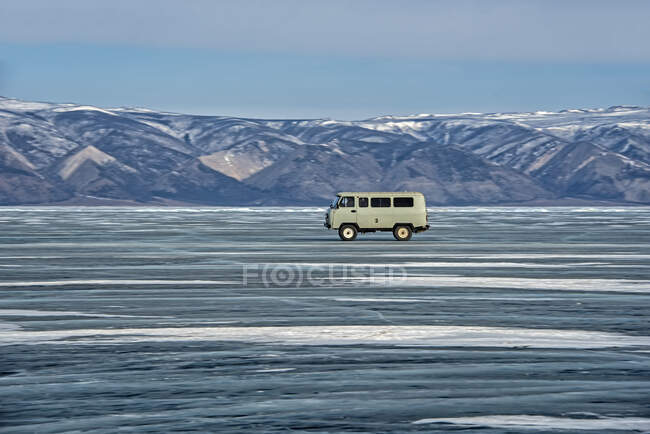 Van conduciendo a través del lago Baikal, Siberia, Rusia - foto de stock