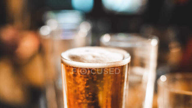 Gros plan d'une pinte de bière et de verres vides sur une table — Photo de stock