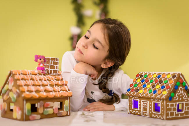 Girl looking at two gingerbread houses — Stock Photo