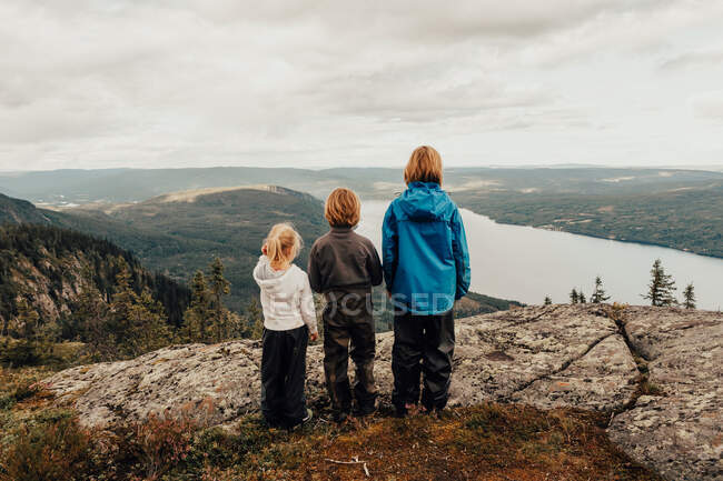 Three children hiking to Vikerfjell looking at view, Norway — Stock Photo