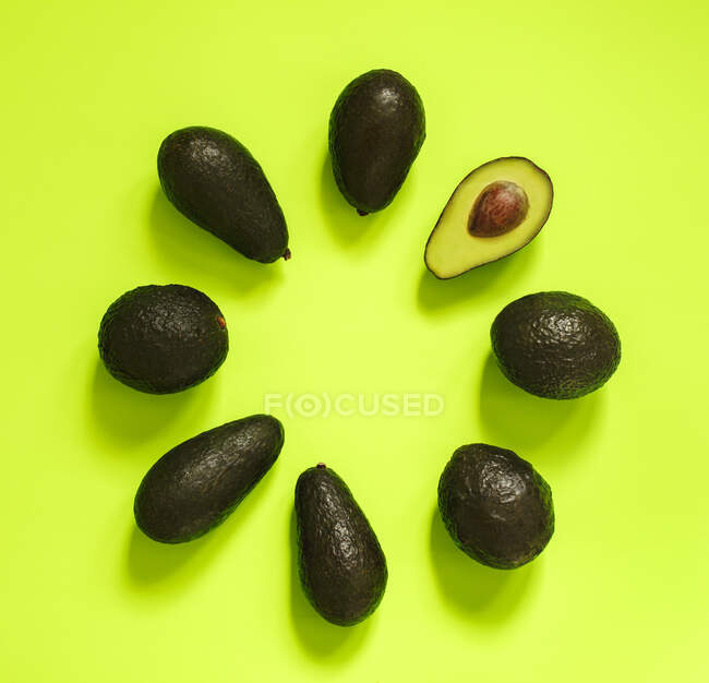 Avocado auf grünem Hintergrund. Ansicht von oben. — Stockfoto