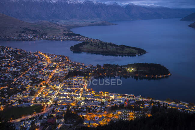 Aerial view of evening illuminated city and bay — Stock Photo