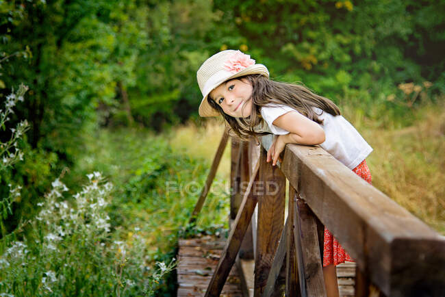 Menina sorridente inclinando-se sobre o lado de uma ponte, Bulgária — Fotografia de Stock