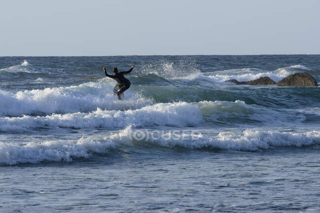 Vista trasera de un hombre surfeando, Playa Sopelana, Vizcaya, España - foto de stock