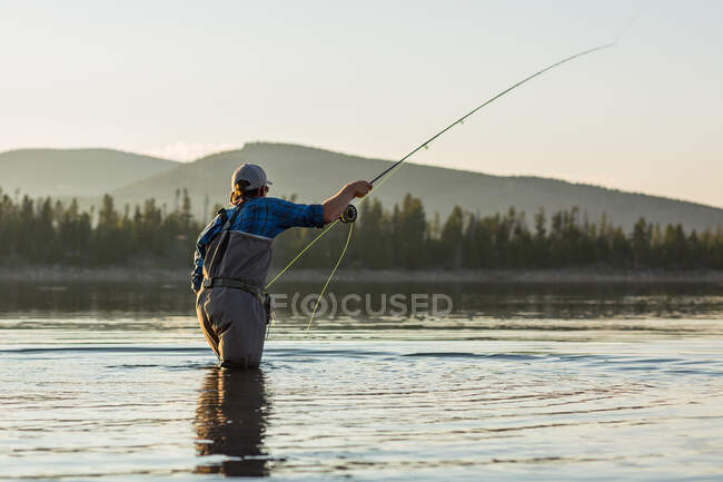 Man standing in river fly fishing, États-Unis — Photo de stock
