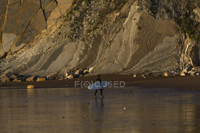 Surfer carrying a surfboard on beach Sopelana, Biscay, Basque Country, Spain — Stock Photo