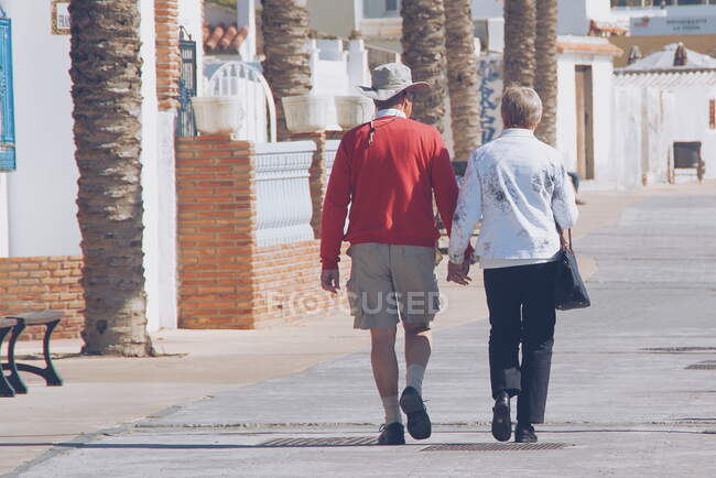 Senioren spazieren an einer Strandpromenade, Malaga, Spanien — Stockfoto