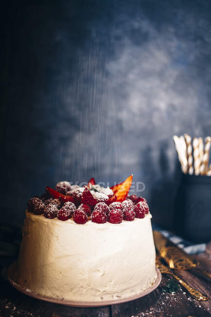 Малиновий і полуничний кремовий торт на дерев'яній дошці. — стокове фото