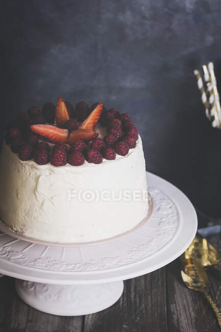 Tarta de crema de frambuesa y fresa en el soporte de la torta, vista cercana - foto de stock