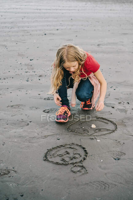 Девушка рисует мокрым песком, пляж Рингшауг, Тонсберг, Норвегия — стоковое фото