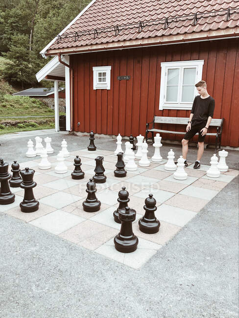 Chico jugando una partida de ajedrez gigante, Baerums Verk, Baerum, Akershus, Noruega - foto de stock