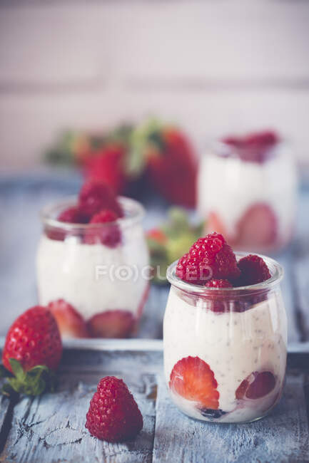 Panelas de iogurte com sementes de chia, morangos e framboesas — Fotografia de Stock