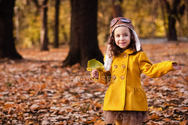 Smiling girl standing in the park holding a leaf, Bulgaria — Stock Photo