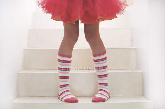 Niña en botas de color rosa sobre fondo blanco - foto de stock