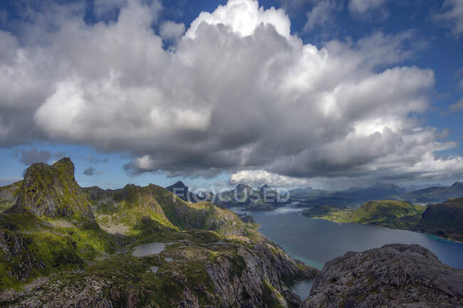 Bellissimo paesaggio montagnoso con lago sotto cielo nuvoloso blu — Foto stock