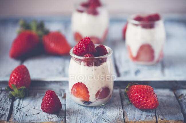 Yogurt con fragole fresche e menta su fondo di legno. focus selettivo. — Foto stock